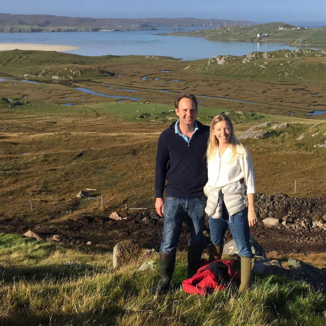 Dickon and Elly smiling with Uig bay and creeks in the background