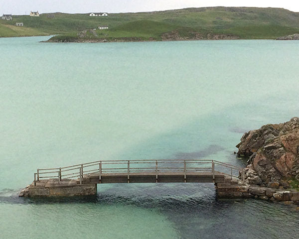 Turquoise river flowing beneath a stone bridge at Uig Lodge on the Isle of Lewis