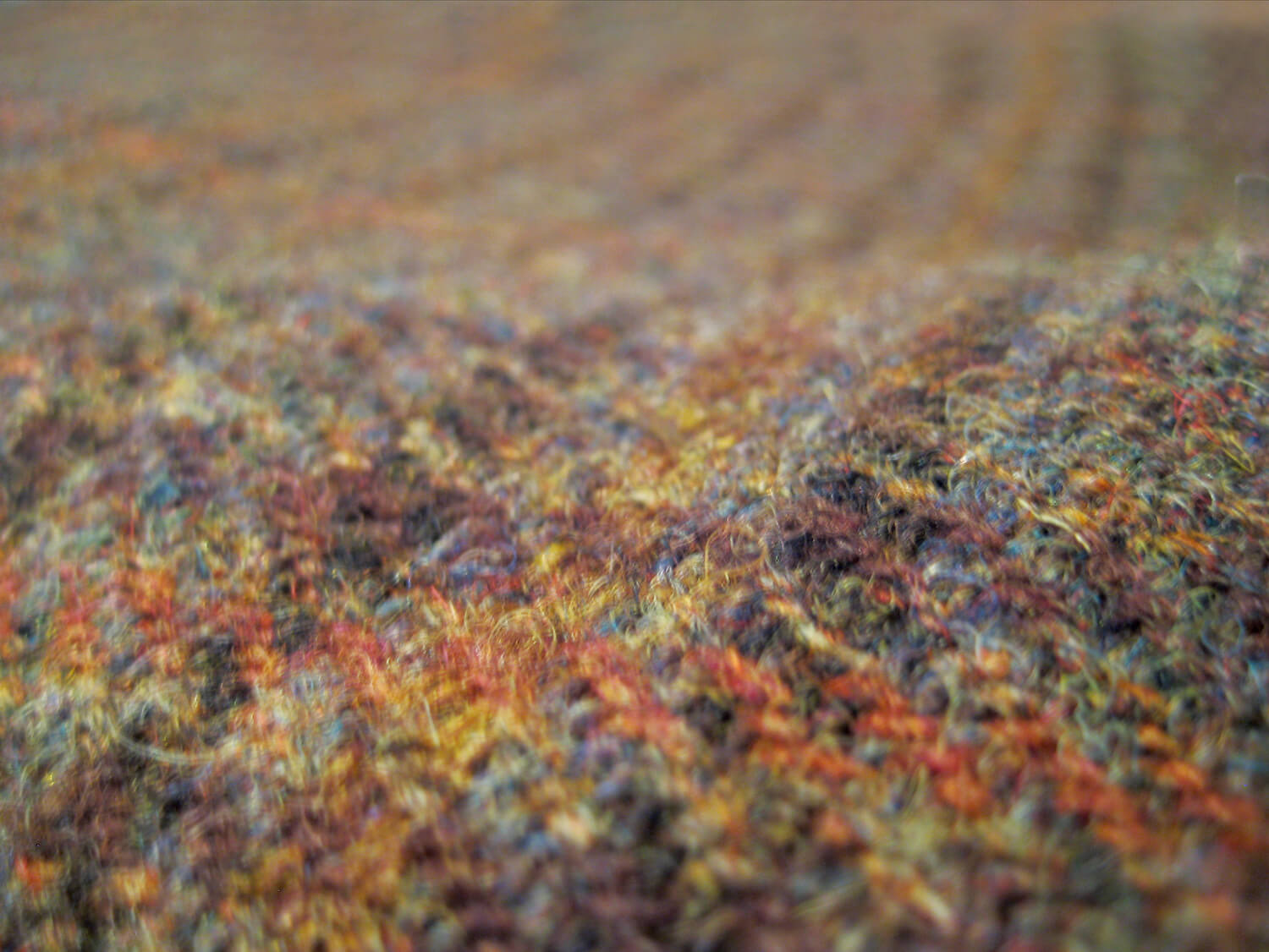 Close-up image of authentic Harris Tweed fabric, showcasing the traditional craftsmanship and heritage linked to the Outer Hebrides near Uig Lodge Private Lettings.