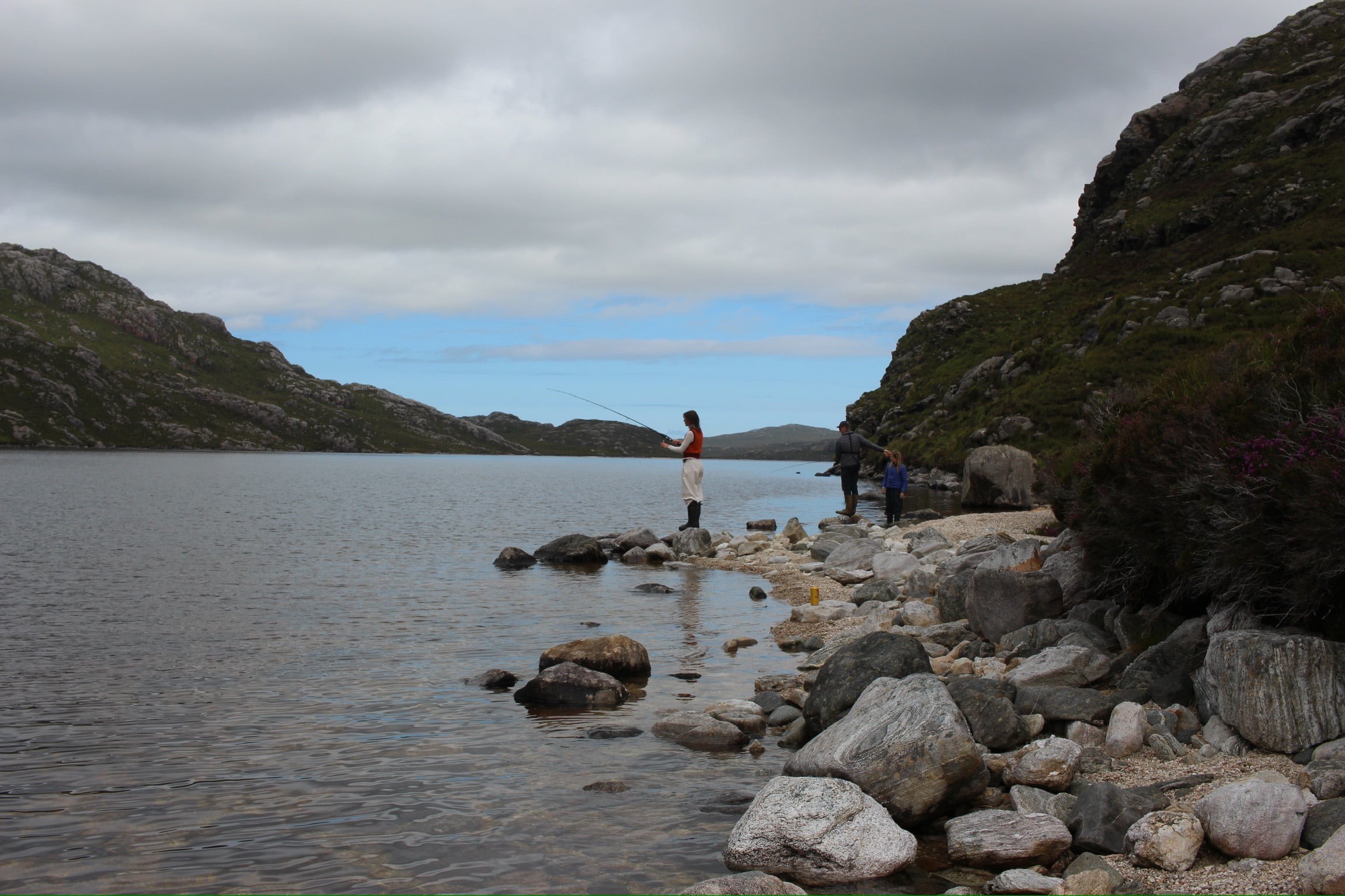 Group of three people fishing on a loch in the scenic landscape of the Isle of Lewis