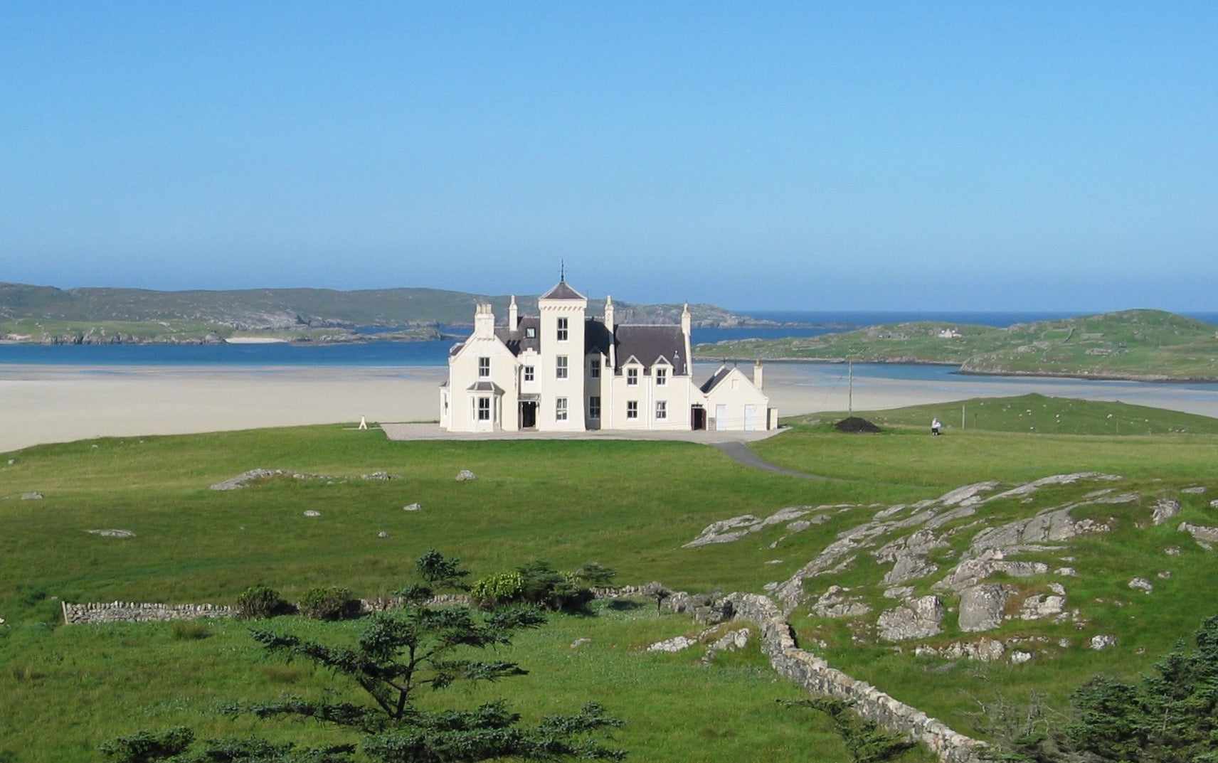 Uig Lodge basking in sunshine, a luxurious coastal retreat on the Isle of Lewis
