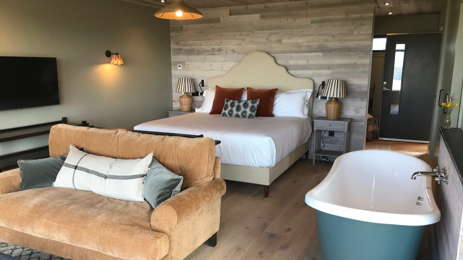 Interior of Uig Sands Rooms private accommodation featuring a cosy double bed, elegant roll-top bath, and a comfortable sofa